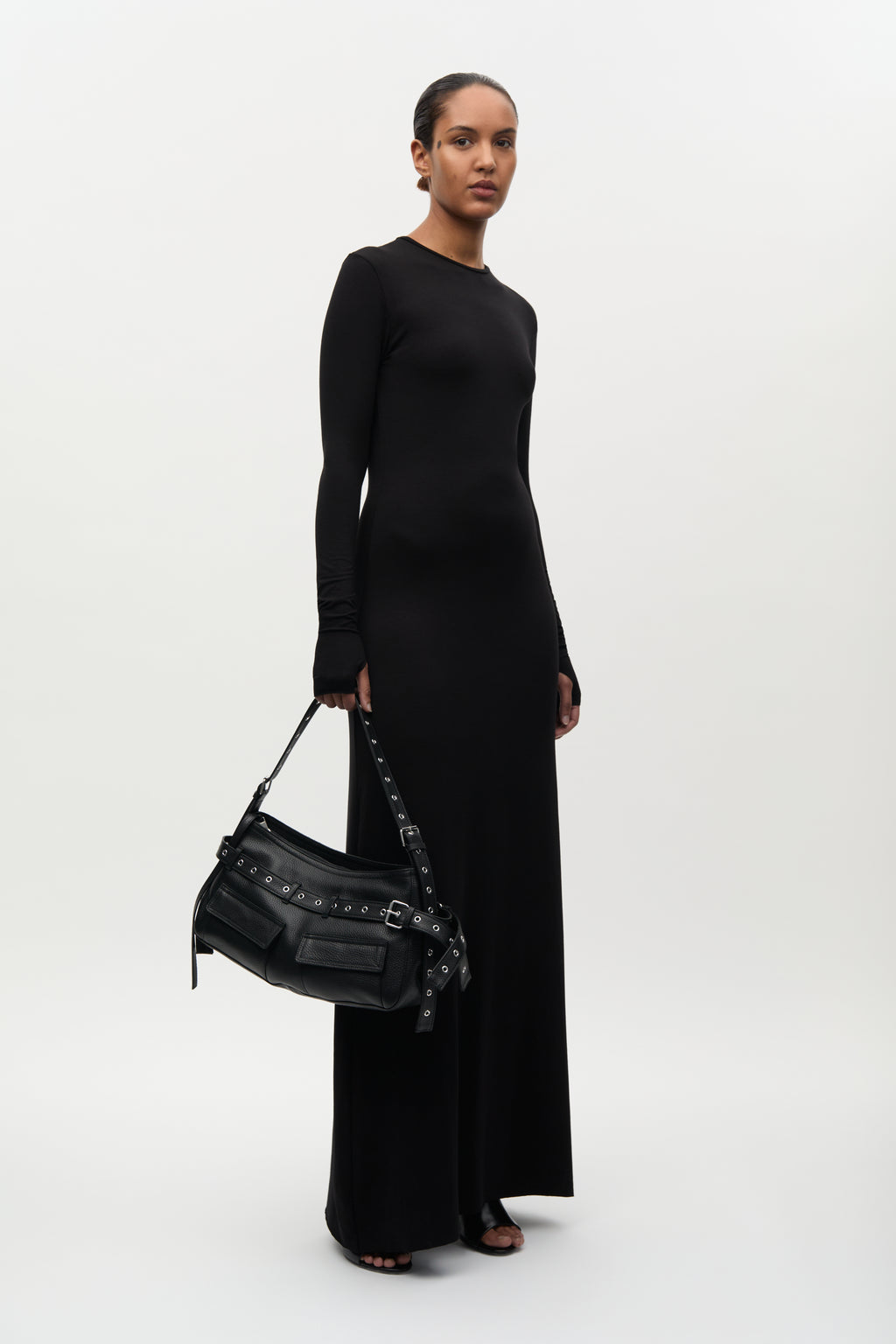 Woman holding a black handbag against a white background