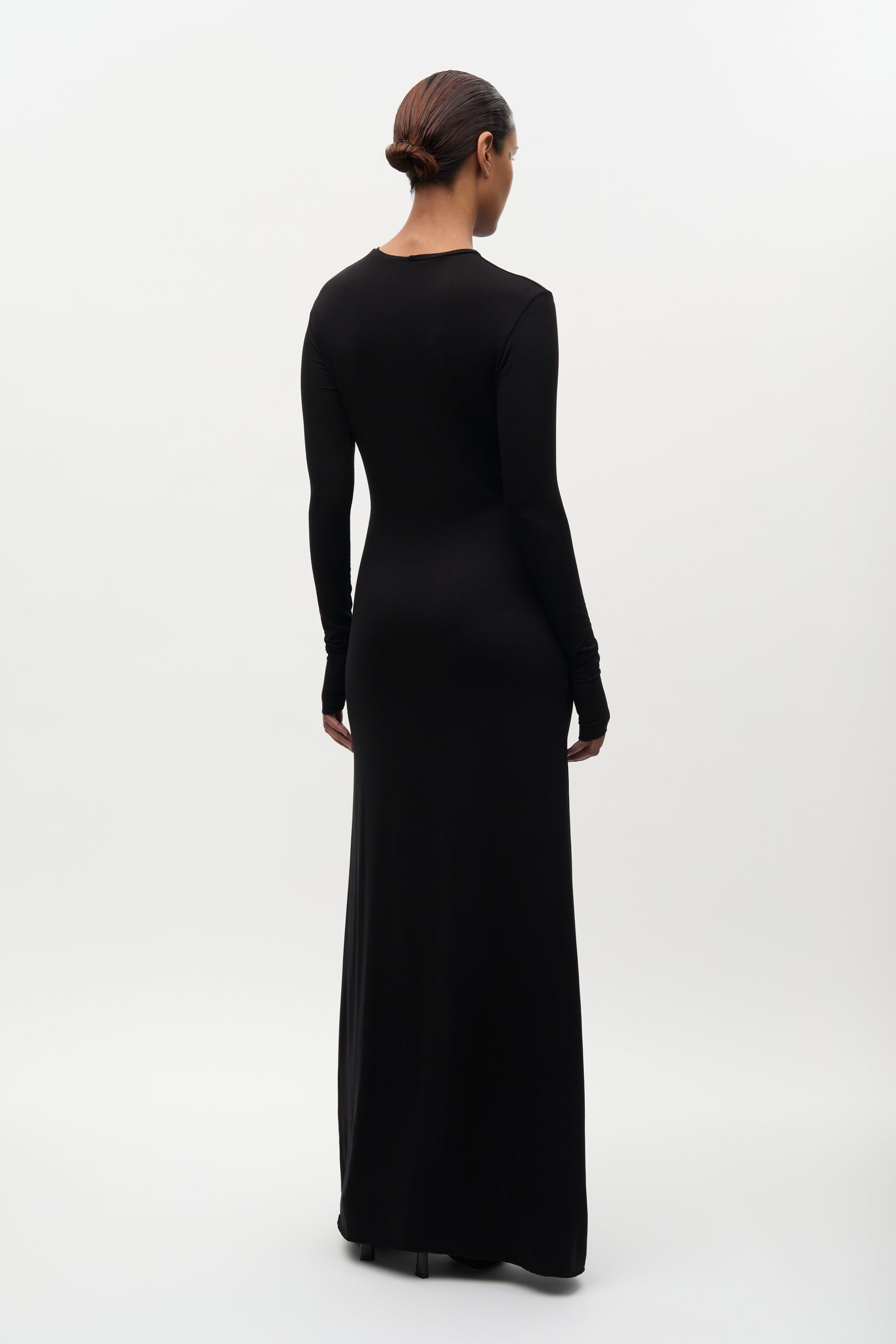 Woman wearing a black long-sleeve gown on a white background