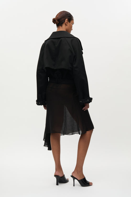 Woman wearing a black coat and skirt set on a white background