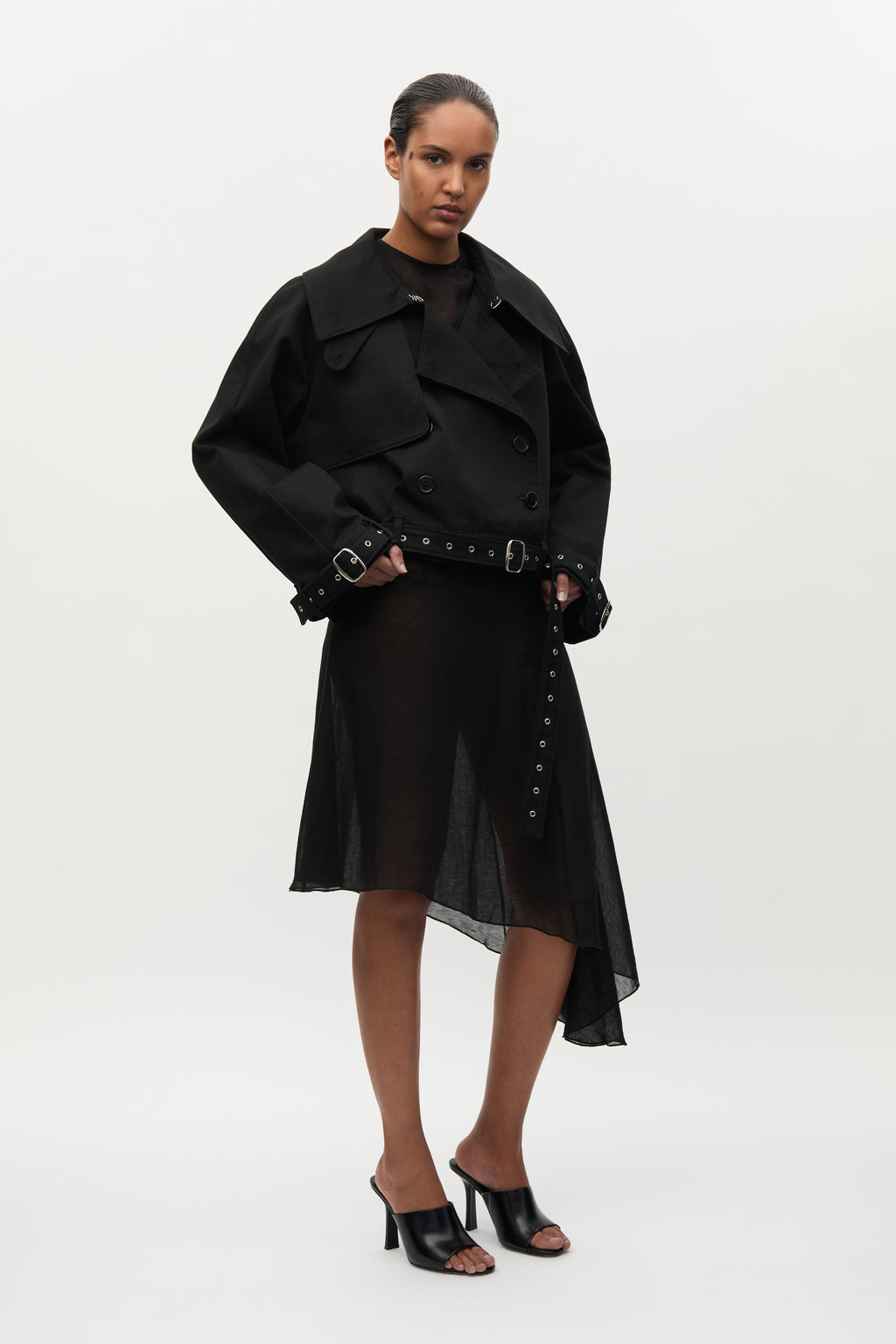 Woman wearing a black coat and skirt set on a white background