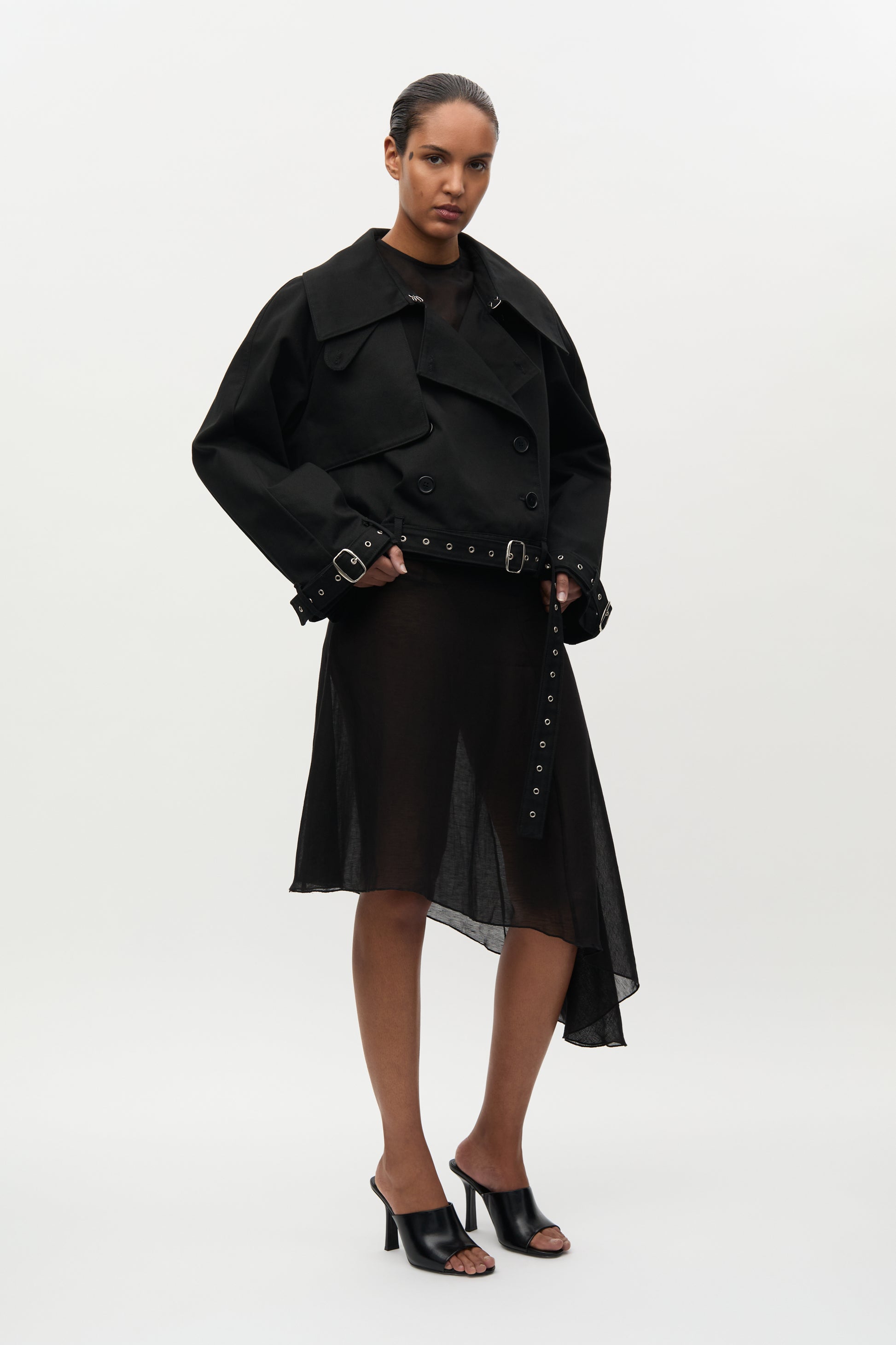 Woman wearing a black coat and skirt set on a white background