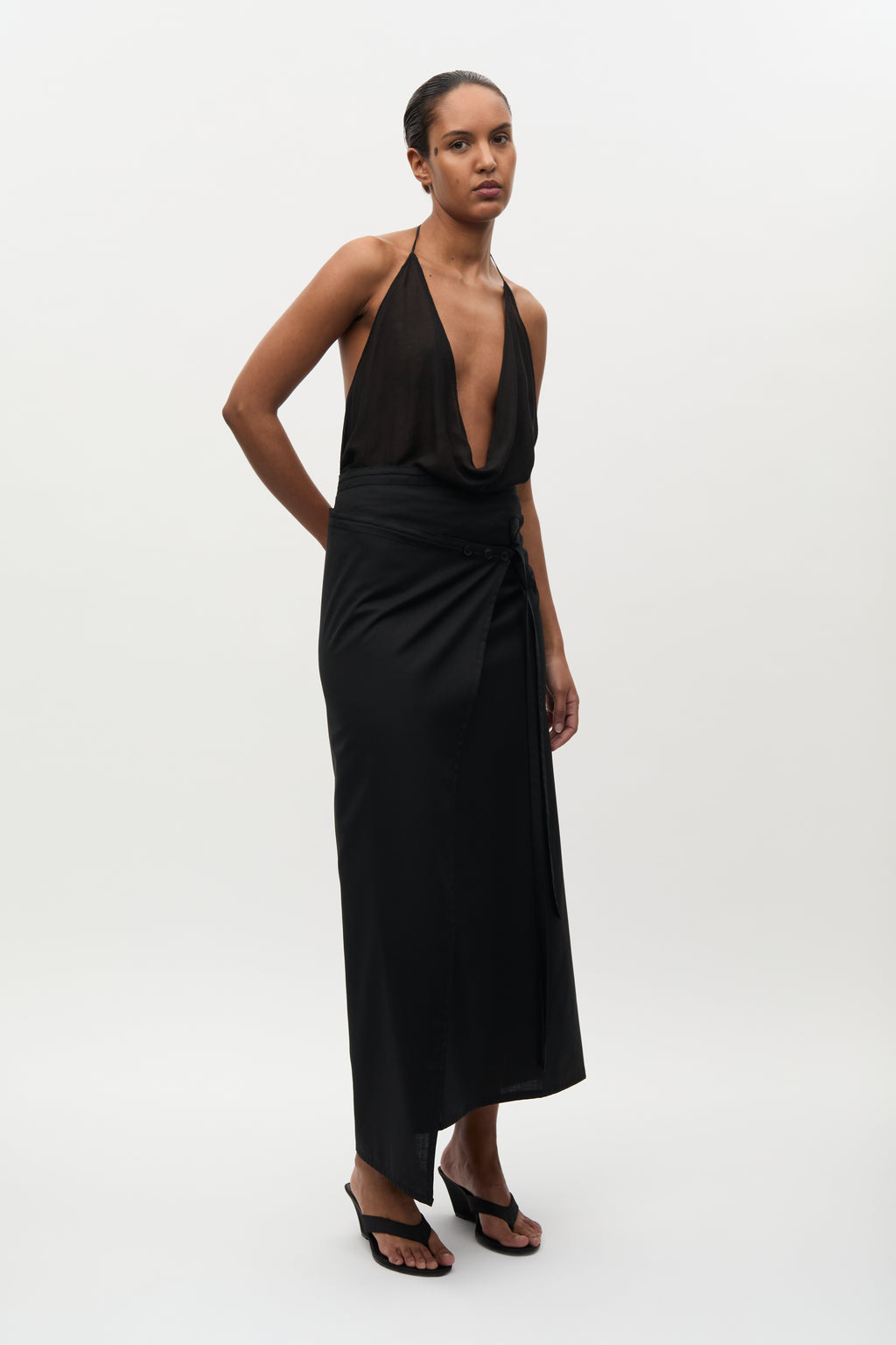 Woman wearing a black halter neck dress on a white background