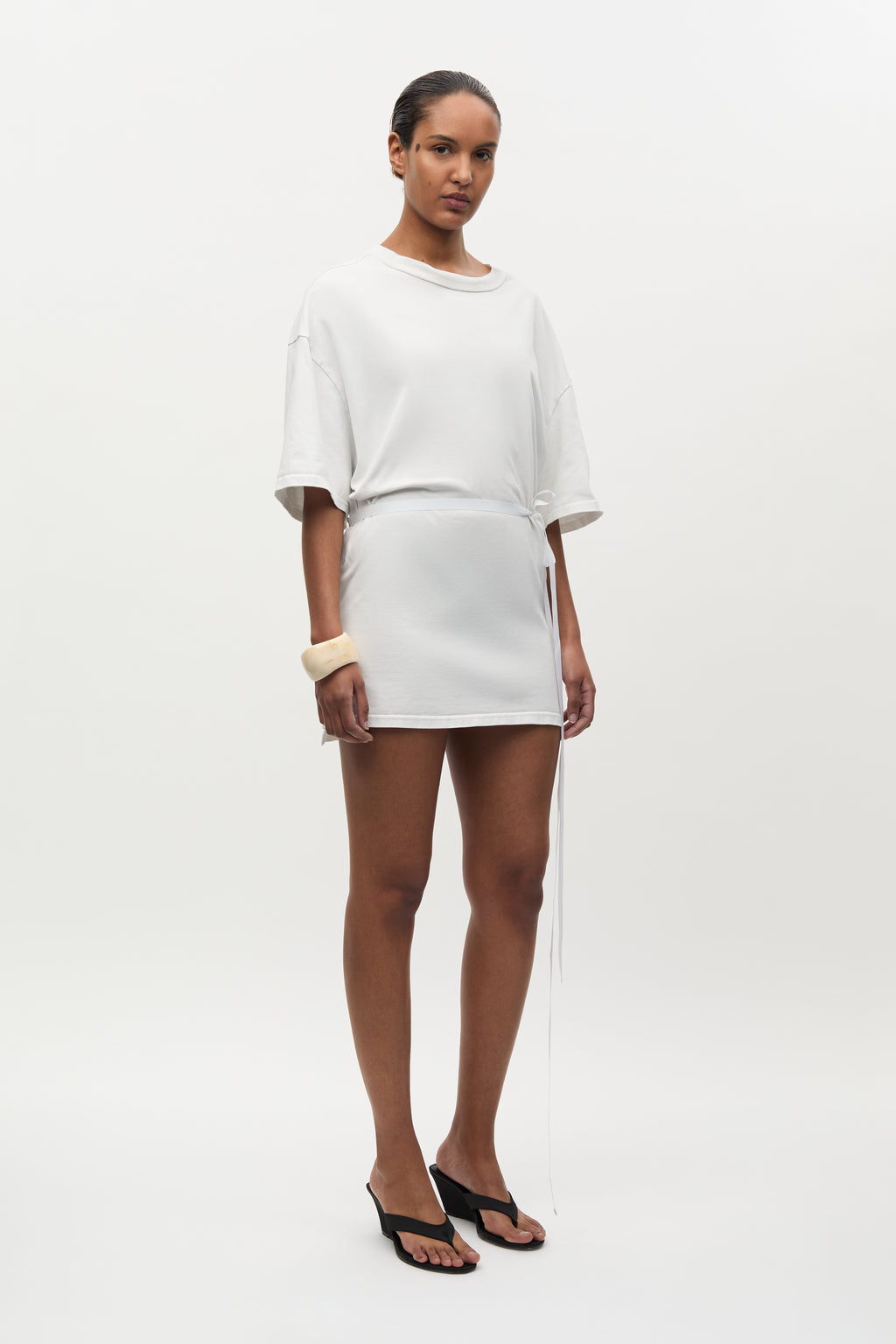 Woman wearing a white outfit on a plain background