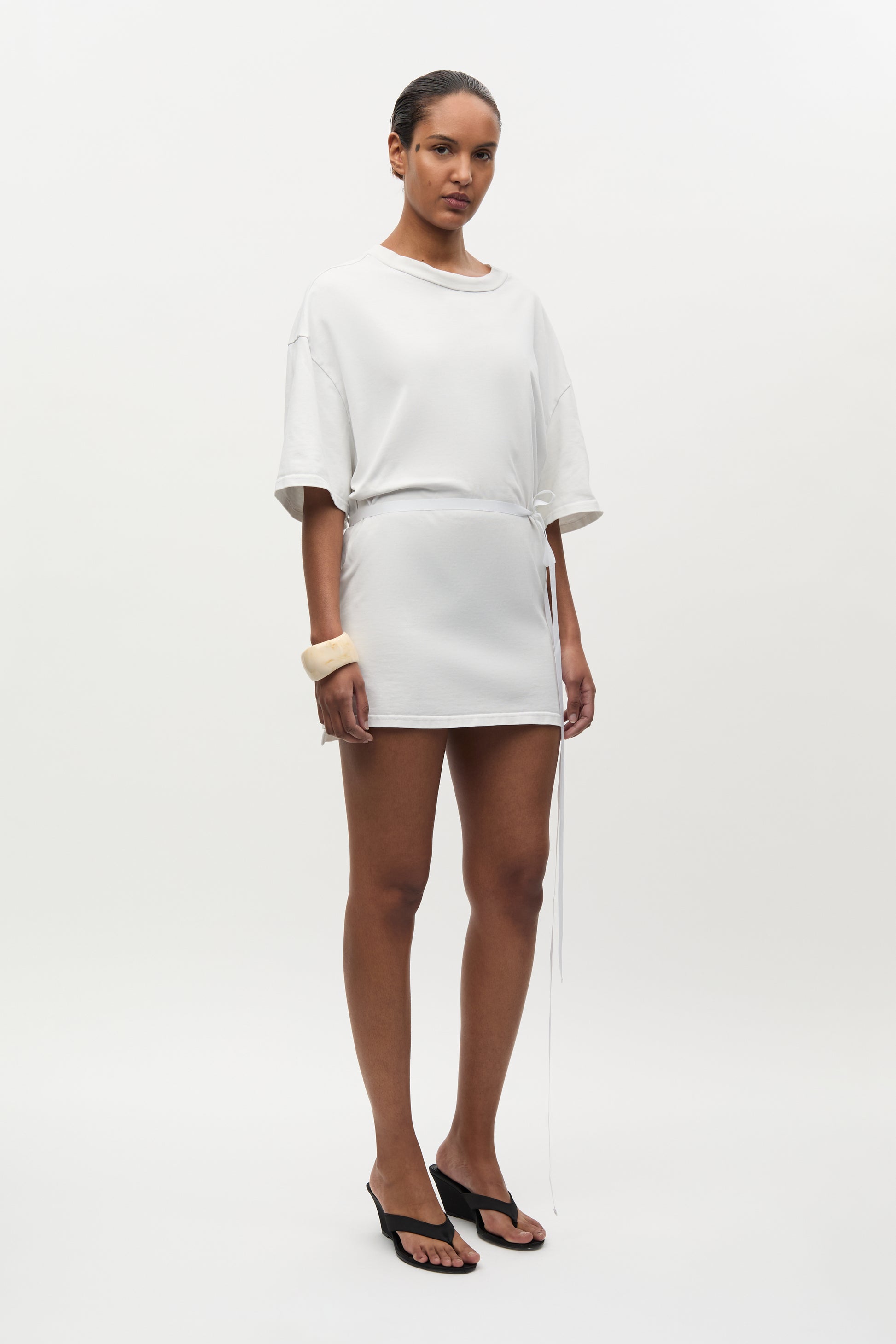 Woman wearing a white outfit on a plain background