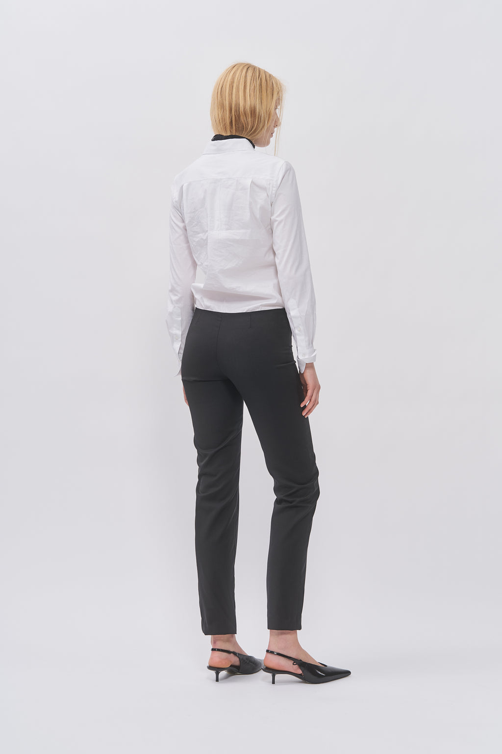 Back view of Taus Low-Waist Trousers in black showing the slim tailored fit