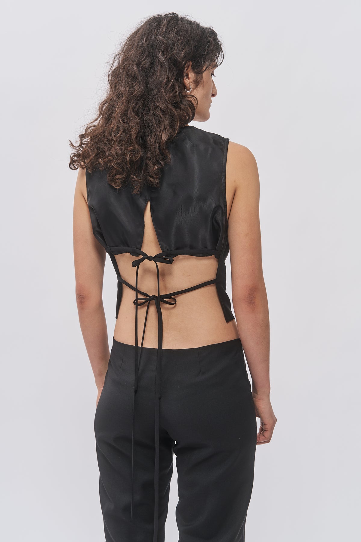Detail of Taus Open-Back Waistcoat in black showing the open back and black tie straps