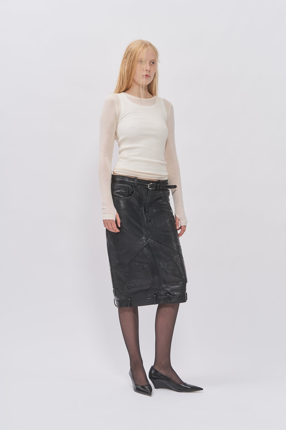 Taus Upcycled Leather Pencil Skirt in black, knee length, styled with a sheer cream top and black tights