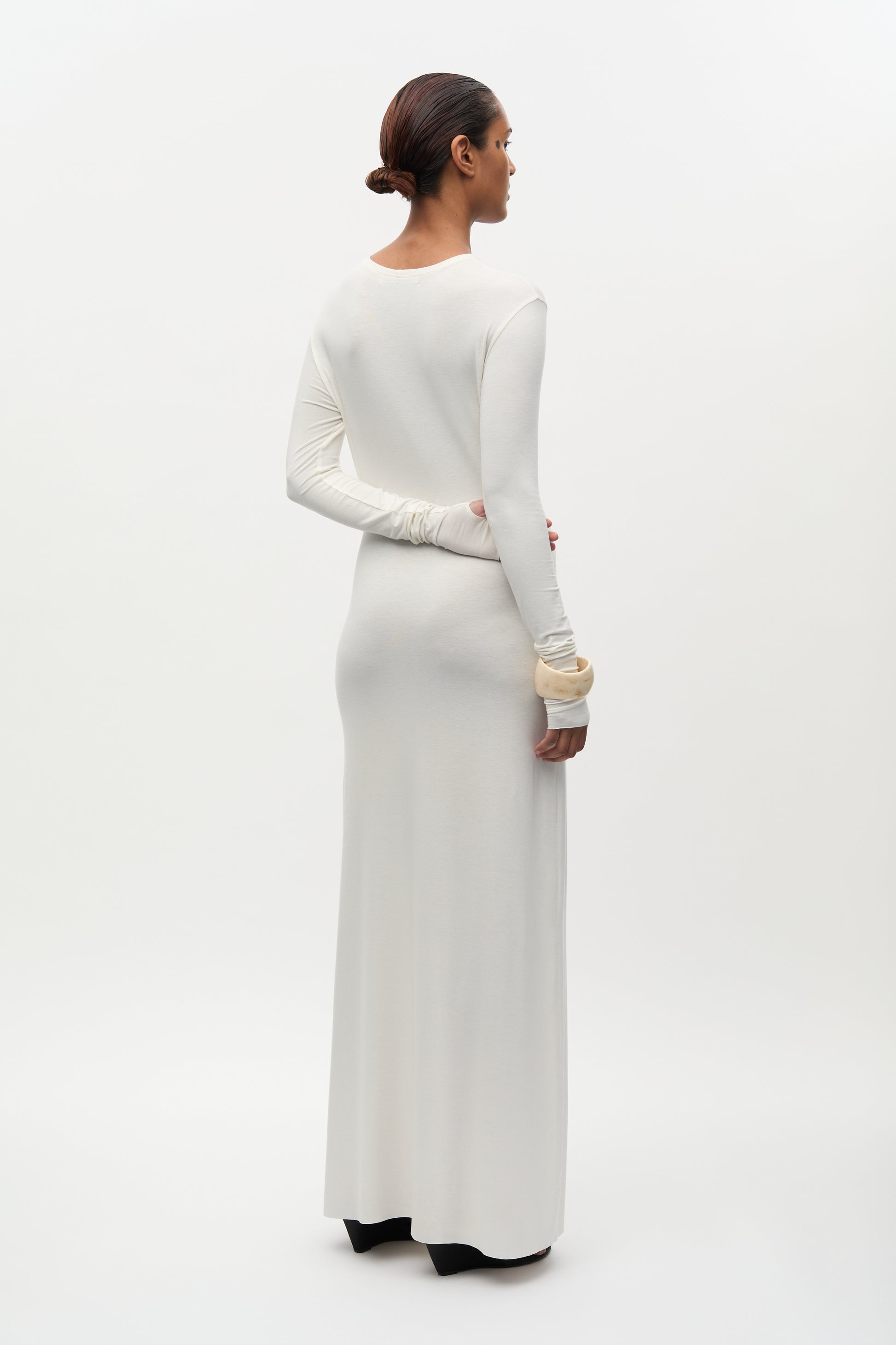 Woman wearing a long white dress on a white background